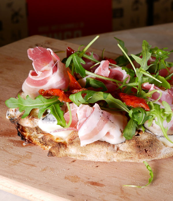 pinsa-condita-nel-forno-vaccani-con-prosciutto-crudo-rucola-e-pomodori-secchi Pinsa con prosciutto crudo rucola e pomodoro | Vaccani